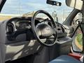 Interior view of a 2002 Ford Econoline with a focus on the steering wheel dashboard and control panel