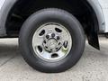A chrome wheel rim with a Chevrolet emblem mounted on a black tire of a 2013 Chevrolet Express