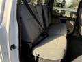The interior of a 2020 Ford F-350 showing the rear seat with grey fabric upholstery and seat belts attached