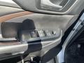 A close-up view of the driver side door panel of a 2018 Toyota Highlander featuring window control buttons and a door handle