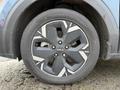 Close-up of a wheel from a 2023 Kia Niro EV featuring a five-spoke design with a combination of black and silver colors