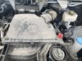 Close-up of the engine compartment of a 2025 Mercedes-Benz Sprinter showing the engine cover with the Mercedes-Benz logo and various components like hoses and tanks