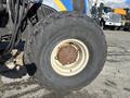 A close-up view of a large, worn tire from a 2010 New Holland T4050 tractor showing significant tread wear and rust around the rim