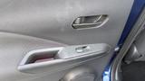 The interior door handle and armrest of a 2019 Nissan Kicks featuring a sleek design with textured surfaces and control buttons