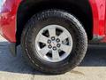 A close-up of a silver alloy wheel and tire of a 2018 GMC Canyon featuring Goodyear Wrangler tire with visible tread pattern and the GMC logo on the wheel center cap