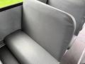 A gray bus seat with a smooth textured surface and a simple design located in the interior of a 2014 Freightliner B2