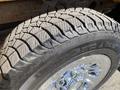 Close-up of a rugged tire with deep treads mounted on a polished chrome wheel showcasing the durable design suitable for off-road conditions