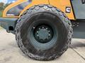 The image shows a close-up of a large wheel from a 2020 Hyundai HR110C featuring a rugged tread pattern and a central hub with a red indicator
