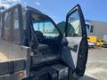 A 1996 GMC Top Kick truck with an open driver's door revealing the interior and dashboard details