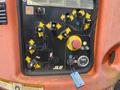 Control panel of a 2009 JLG E300AJP with various buttons switches and a key for operation