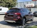 A 2017 Infiniti QX50 in a deep burgundy color with a sleek design and dual exhaust pipes visible at the rear