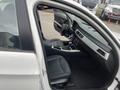 Interior view of a 2011 BMW 3-Series showcasing the driver's seat dashboard and console with black leather upholstery and silver accents