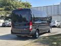 A black 2025 Ford Transit T-350 van is parked with its rear facing the viewer showcasing its sleek design and large cargo space