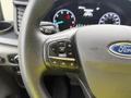 Close-up of the steering wheel of a 2023 Ford Transit featuring control buttons for setting speed and adjusting features