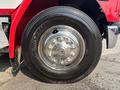 A close-up view of a 1999 Freightliner FL80 tire showcasing a shiny chrome wheel with multiple bolts and a Michelin tire with a tread pattern