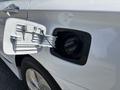 Close-up of a fuel door on a white 2014 Hyundai Sonata with the door partially open revealing the gas cap inside