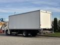 A 2022 Lion Lion6 truck with a large white box cargo area and dual rear wheels parked on a street
