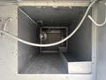 A metal storage compartment of a 2005 Freightliner M2 106 featuring a smooth interior and a diamond plate floor with a light fixture mounted on the side