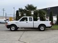 A white 2011 Ford Ranger pickup truck is parked with its driver side facing the viewer showcasing its cab and bed design