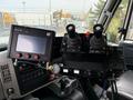 The interior control panel of a 2016 International 7600 featuring joystick controls a digital display and various buttons and gauges