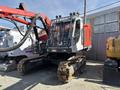 A 2018 Sandvik Ranger DX800 drilling machine with a robust tracked chassis and a large cab featuring a protective grille and multiple lights on top
