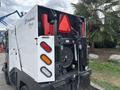 A 2019 Madvac LS175 street sweeper with a white body featuring red and black details in the rear including lights and a hydraulic system