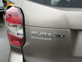 A silver 2016 Subaru Forester with a visible rear badge that reads Subaru and Symmetrical AWD on the back