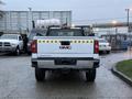 A 2017 GMC Sierra 3500HD truck viewed from the rear with reflective safety stripes on the tailgate and a bed liner visible inside the truck bed