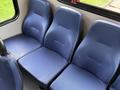 Three blue upholstered seats positioned in a row inside a vehicle