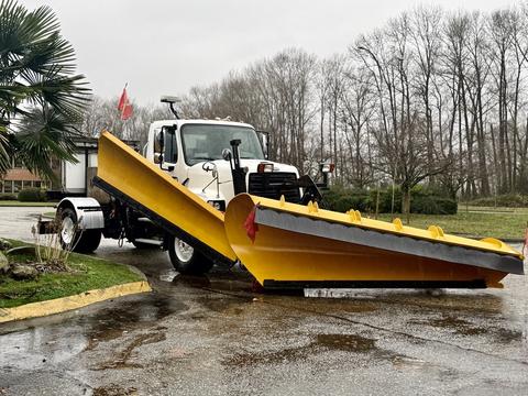 A 2016 Freightliner 108SD equipped with a large yellow snow plow mounted on the front