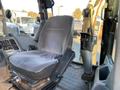 A worn gray seat inside a 2007 Komatsu WB156PS-5 heavy machinery cab with visible controls and levers