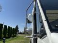 A 2012 Ford Econoline with chrome side mirrors and a white body viewed from an angle highlighting the driver's side mirrors and window