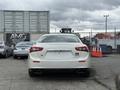 A white 2016 Maserati Ghibli viewed from the rear showing its sleek design and dual exhaust tips