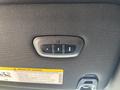 Close-up of a control panel featuring three buttons on a textured surface with warning labels in French and English