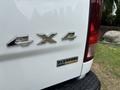 A 2013 RAM 1500 truck with a white body showing the 4x4 emblem and a Flex Fuel badge on the tailgate