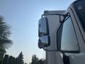 A 2012 Hino 338 truck side mirror reflecting the surroundings with a shiny chrome finish