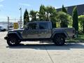 A 2021 Jeep Gladiator in gray with black wheels parked on a concrete surface