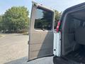 A 2021 Chevrolet Express van with the passenger side door open showcasing the interior space