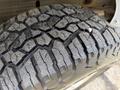 Close-up of a tire tread from a 2019 Chevrolet Silverado 1500 showing deep grooves and a metal object embedded in the rubber