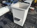 A white square bucket with a foot pedal on the side placed on the top of a vehicle