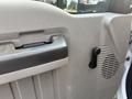 Interior door handle of a 2009 Ford F-550 with a latch and speaker grille visible on the door panel