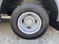 The image shows a close-up of a wheel from a 2012 Ford Econoline featuring a silver rim and a black tire with visible tread patterns