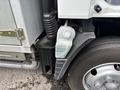A 2015 Mitsubishi Fuso FE160 with a visible coolant reservoir located near the front wheel and fender