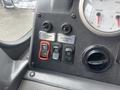 Control panel of a 2006 E-One Typhoon featuring buttons for mirror adjustment and start stop functions along with gauge indicators for transmission and volume