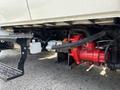 A red pump mounted on the side of a 2006 International 4300 truck with visible pipes and connections