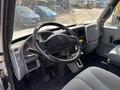 Interior view of a 2006 International 4300 featuring a steering wheel dashboard controls and seats in a light gray color