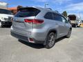 A silver 2018 Toyota Highlander viewed from the rear with a curved roofline and distinctive taillights showcasing a modern SUV design