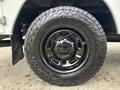 A close-up of a black wheel with a rugged tire designed for a 2013 Ford F-250 SD showing detailed tread patterns and a shiny rim