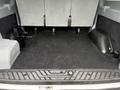 Interior cargo area of a 2018 Ford Transit with three rear seats removed and a black carpeted floor