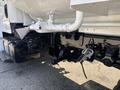 A close-up view of a 2014 Freightliner M2 106 featuring plumbing and hydraulic components attached to the chassis